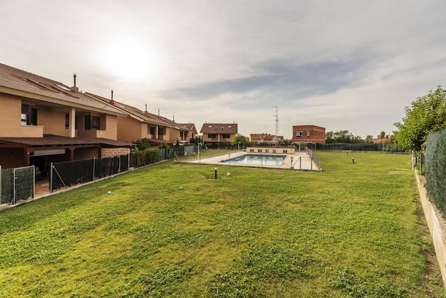 Piscina rodeada de terreno con césped y viviendas unifamiliares a su alrededor