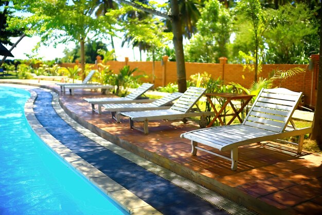 Foto piscina con sillas de sol en un día soleado