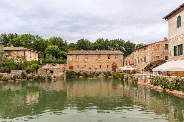 Piscina termal na praça central de Bagno Vignoni cercada por edifícios históricos renascentistas