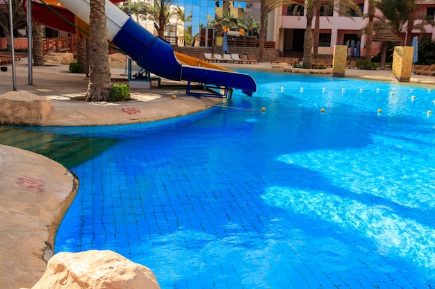 Piscina con tobogán de agua en el resort de verano tropical