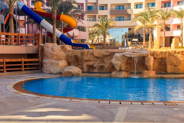 Piscina con tobogán de agua en el resort de verano tropical