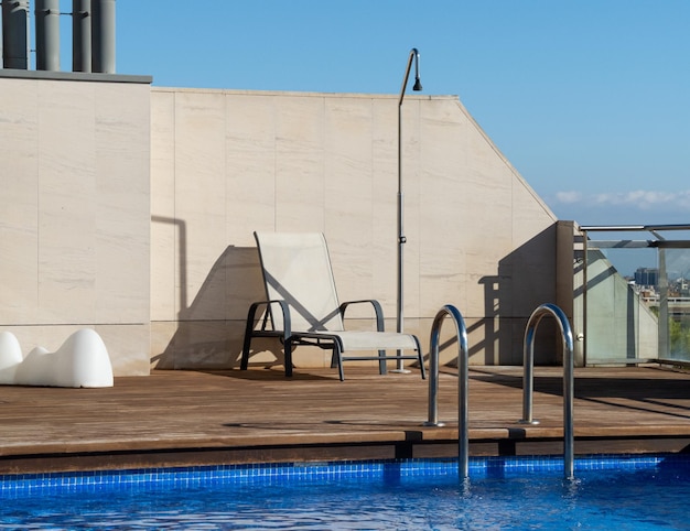 Piscina con tumbona en la azotea con cielo azul claro