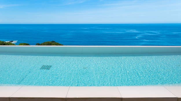 Piscina con vistas al mar andaman y cielo despejado, vacaciones de verano.