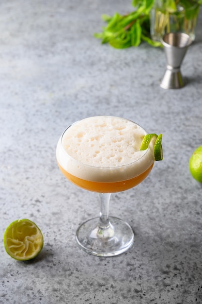 Pisco saurer Whiskycocktail, Limette auf Grau.