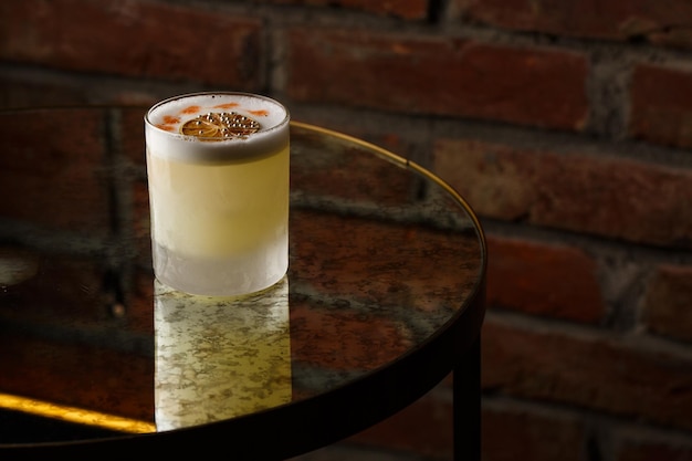 Pisco sour cocktail whisky con jarabe de azúcar de clara de huevo de lima en vidrio sobre fondo oscuro Espacio para texto