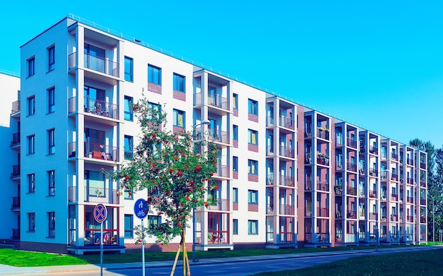 Piso en edificio residencial exterior. Estructura de vivienda en la casa moderna azul de Europa. Casa de alquiler en el distrito de la ciudad en verano. Alta arquitectura de paredes y vidrios para inversión inmobiliaria empresarial.