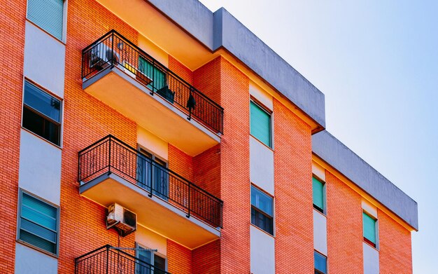 Piso en edificio residencial exterior. Estructura de vivienda en la casa moderna azul de Europa. Casa de alquiler en el distrito de la ciudad en verano. Alta arquitectura de paredes y vidrios para inversión inmobiliaria empresarial.