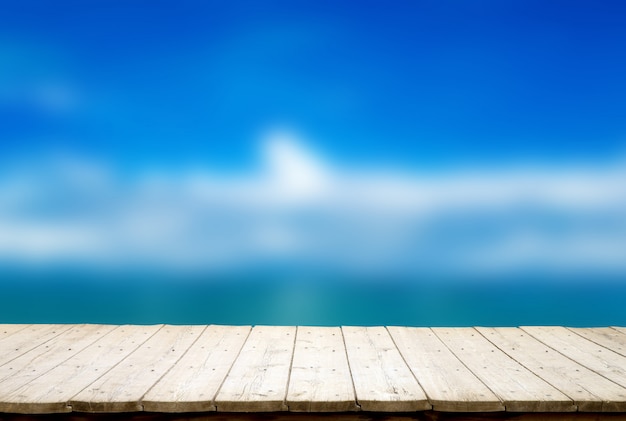 Foto piso de madera en el fondo borroso playa de arena. playa y mar tropical