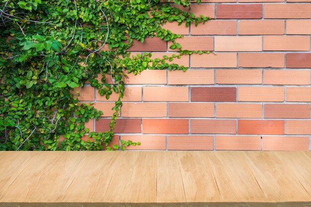 Foto piso de madera con fondo de pared de ladrillo rojo y planta verde