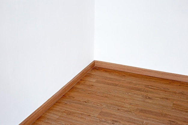 Piso de madera laminada con pared blanca en blanco