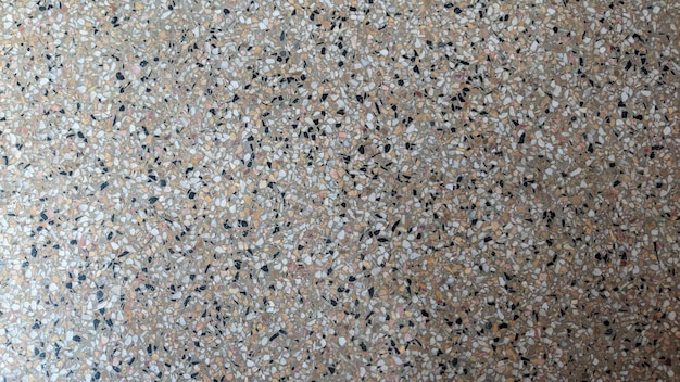 Un piso con un patrón de piedras pequeñas y un objeto blanco.