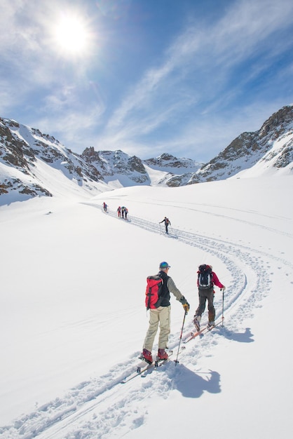 Pista de ascenso de esquí de montaña en los alpes suizos con gente escalada