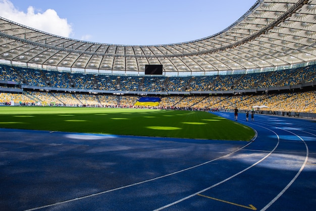 Pista de atletismo azul vacía en el estadio olímpico con el telón de fondo de gradas vacías