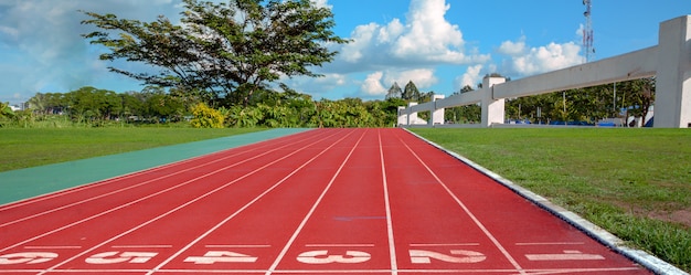 Pista de atletismo con carriles sobre el cielo y las nubes.