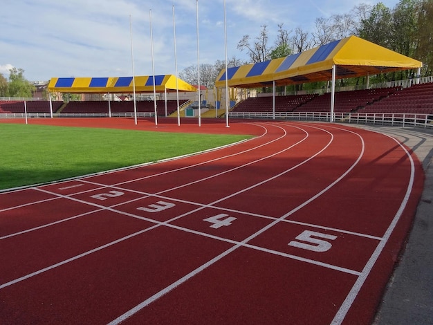 Pista de atletismo en el estadio deportivo con tribuna cubierta