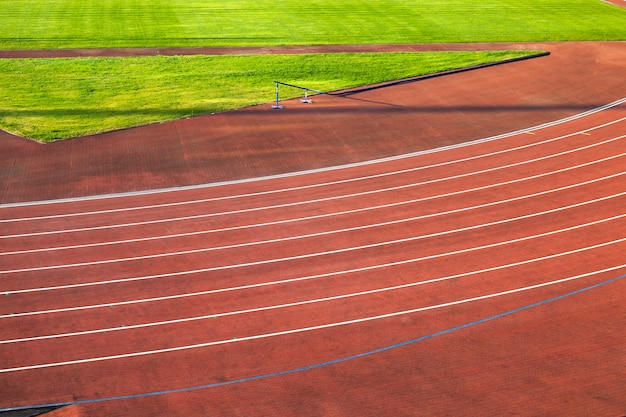 Pista de atletismo roja dividida por la banda. El estadio