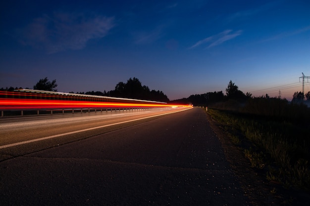 Foto pista noturna com luzes desfocadas dos faróis dos carros. longo tempo de exposição.