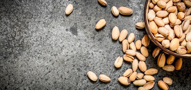 Pistachos en un bol. Sobre fondo rústico.