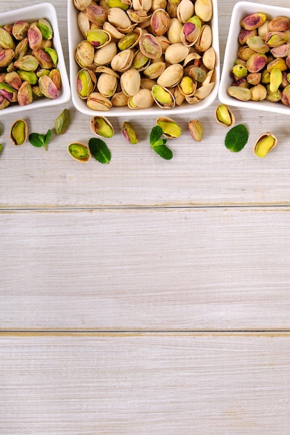 Foto pistachos en el fondo de madera blanco