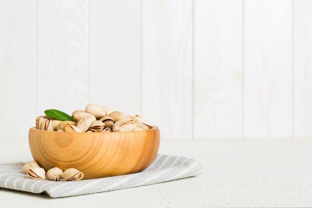 Pistachos frescos y saludables en un tazón sobre fondo de mesa de color Vista superior Concepto de alimentación saludable Súper alimentos