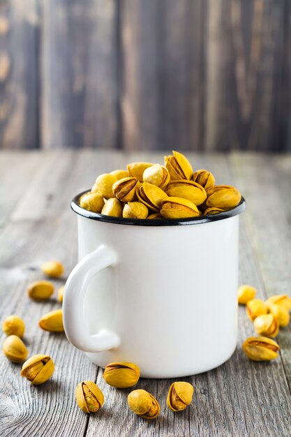 Pistachos salados con azafrán en taza de hierro. Enfoque selectivo.