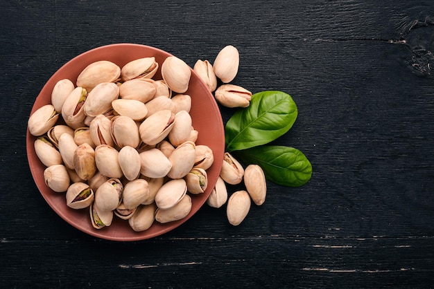 Pistachos sobre un fondo de madera oscura Aperitivos saludables Vista superior Espacio libre para texto