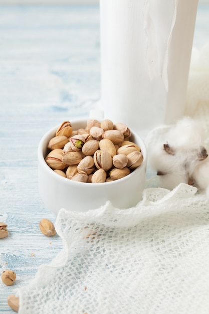 Pistachos en una taza de cerámica blanca sobre un blanco