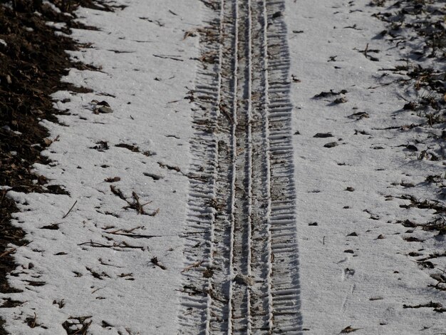 Foto pistas de pneus de carro na neve fresca.