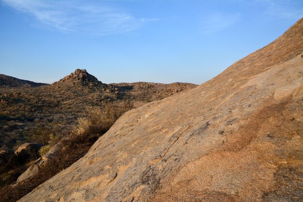 Pistas de uma montanha rochosa no deserto com arbustos esparsos Reserva de paisagem natural