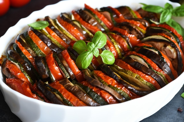 Pisto de verduras sobre un fondo de hormigón negro. Verduras al horno en la mesa de la cocina.