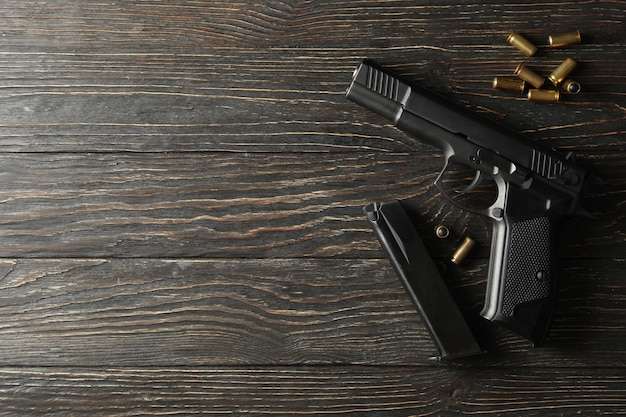 Foto pistola, balas y cargador en madera.