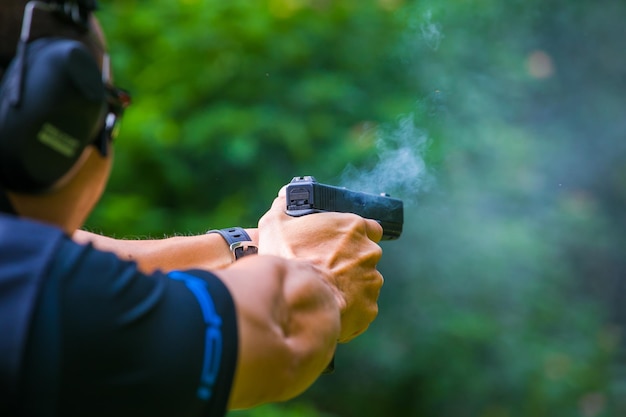 Pistola de arma de mão em uma mão de homem