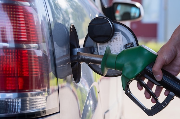 Pistola de posto de gasolina na mão do motorista. Bomba de posto de gasolina moderna, excelente design para qualquer finalidade. O motorista do carro.