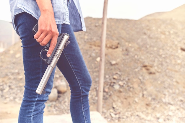 Pistola en las manos de una chica disparando con una pistola