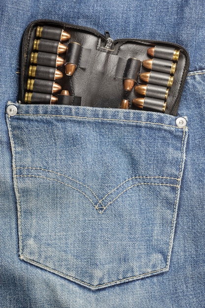 Pistola no bolso da calça jeans.