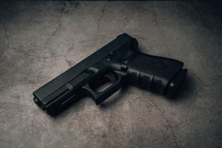 Foto pistola preta de 9 mm em uma antiga vista superior do piso de concreto