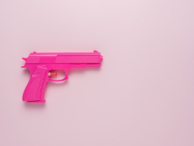 Pistola rosa em fundo rosa pastel