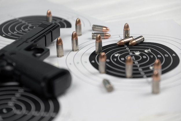 Foto pistole und viele kugeln, die ziele auf weißem tisch im schießstand-polygon schießen training zum zielen und schießen