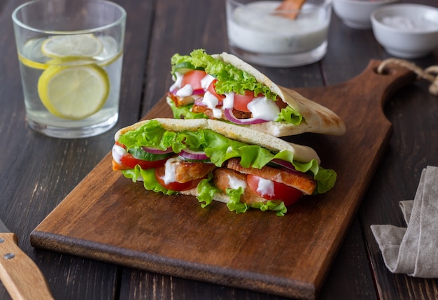 Pita mit Hühnchen, Tomaten, Gurken, Zwiebeln, Salat und weißer Sauce. Döner Kebab. Gesundes Essen. Diät.