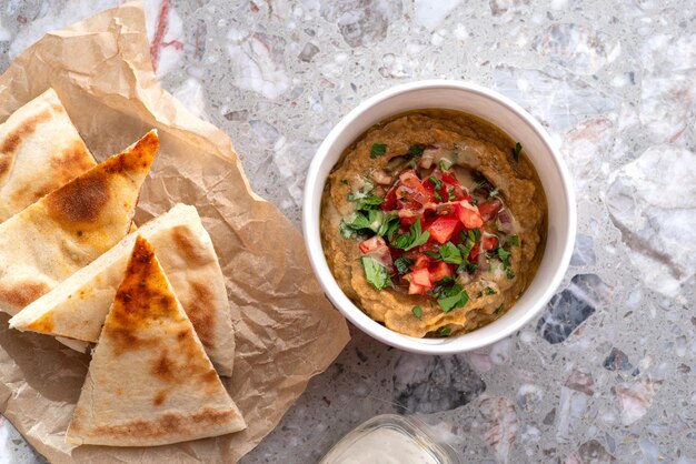 Pita mit verschiedenen traditionellen griechischen Dips Gemüsekaviar-Spezialität Baba Ganoush mit frischen Tomaten und Petersilie auf hellem Hintergrund