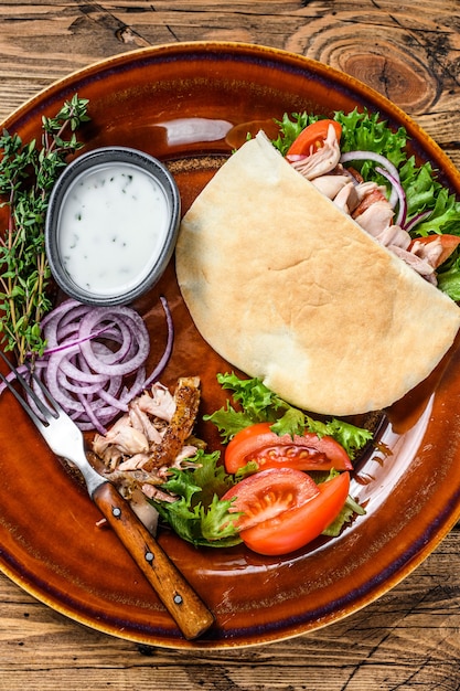 Pita-Salat mit gebratenem Huhn und Gemüse auf einem Teller.