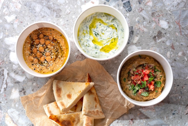 Pita con una variedad de salsas griegas tradicionales hummus de caviar vegetal tzatziki sobre fondo claro