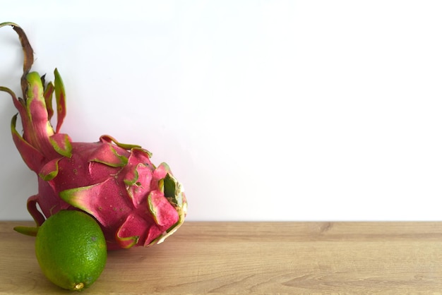 Pitaya oder Drachenfrucht mit Kalk auf Holztisch