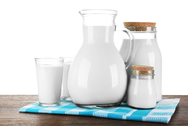 Pitcher-Gläser und Gläser Milch auf Holztisch auf weißem Hintergrund