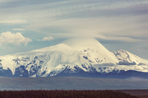 Pitorescas montanhas do Alasca no verão. Maciços cobertos de neve, geleiras e picos rochosos.