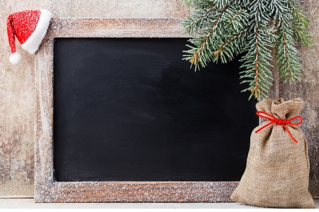 Pizarra de Navidad y decoración sobre fondo de madera.