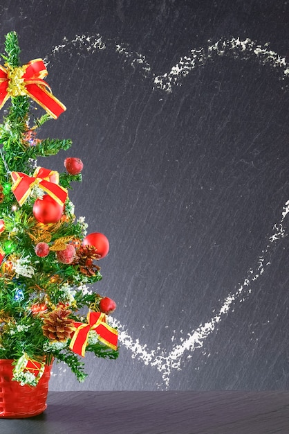 Foto pizarra negra decorativa de fondo de navidad o año nuevo enmarcada con adornos para árboles de navidad