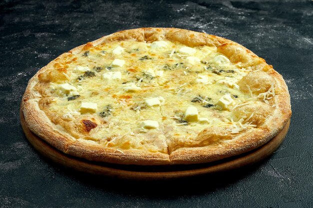 Pizza con 4 tipos de quesos sobre un fondo de piedra negra. ángulo de visión de 45 grados. primer plano, enfoque selectivo