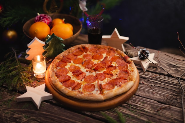 Pizza con adornos navideños en mesa de madera