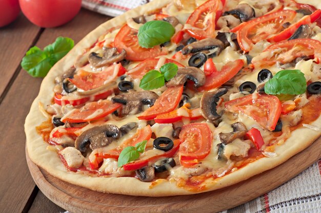 Pizza apetitosa com frango, tomate, pimentão e cogumelos